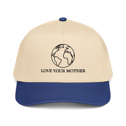 Love Your Mother globe embroidery on a tan and navy 5-panel cap